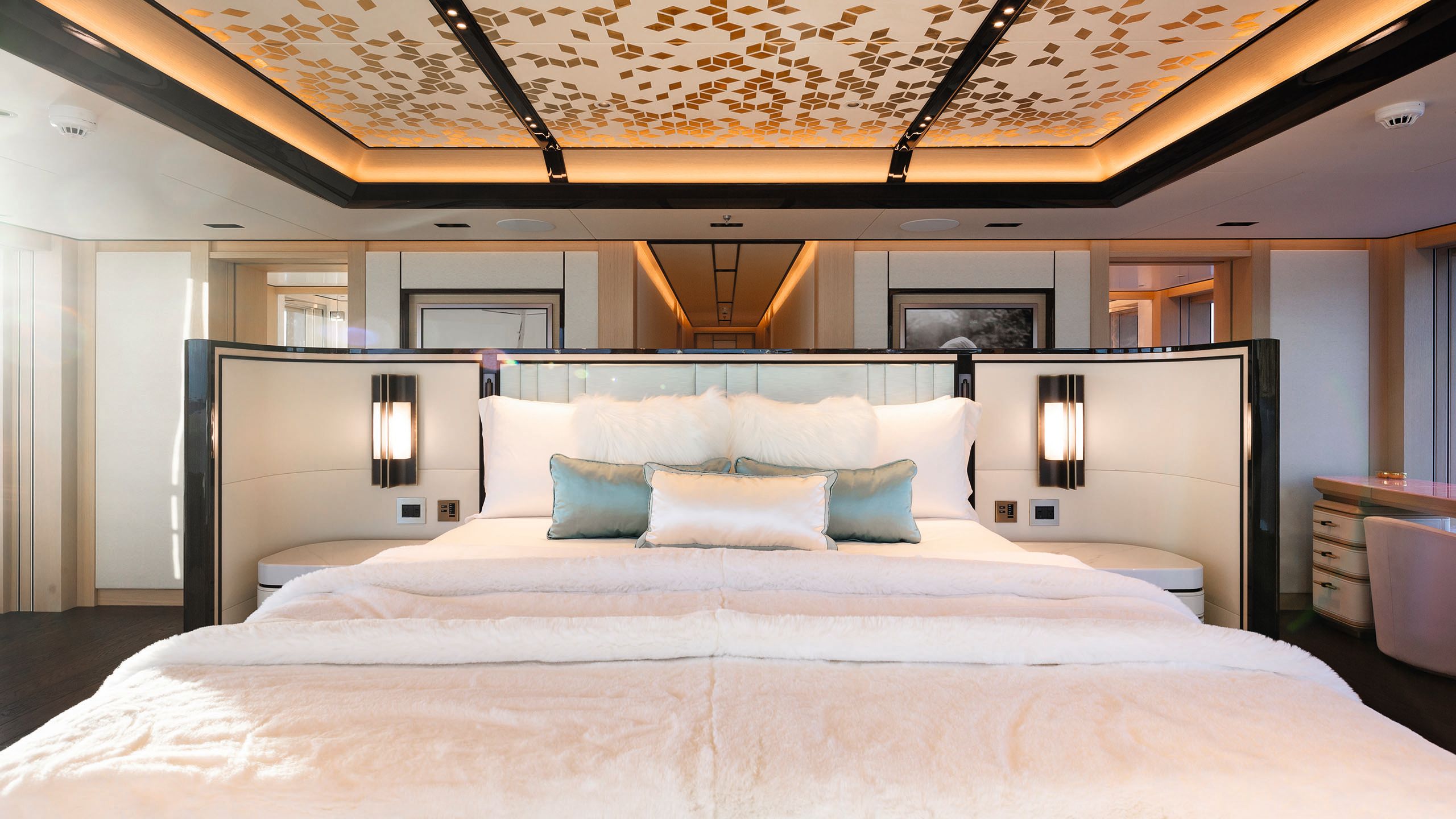 Large bed at the centre of a room that has a gold-flecked ceiling