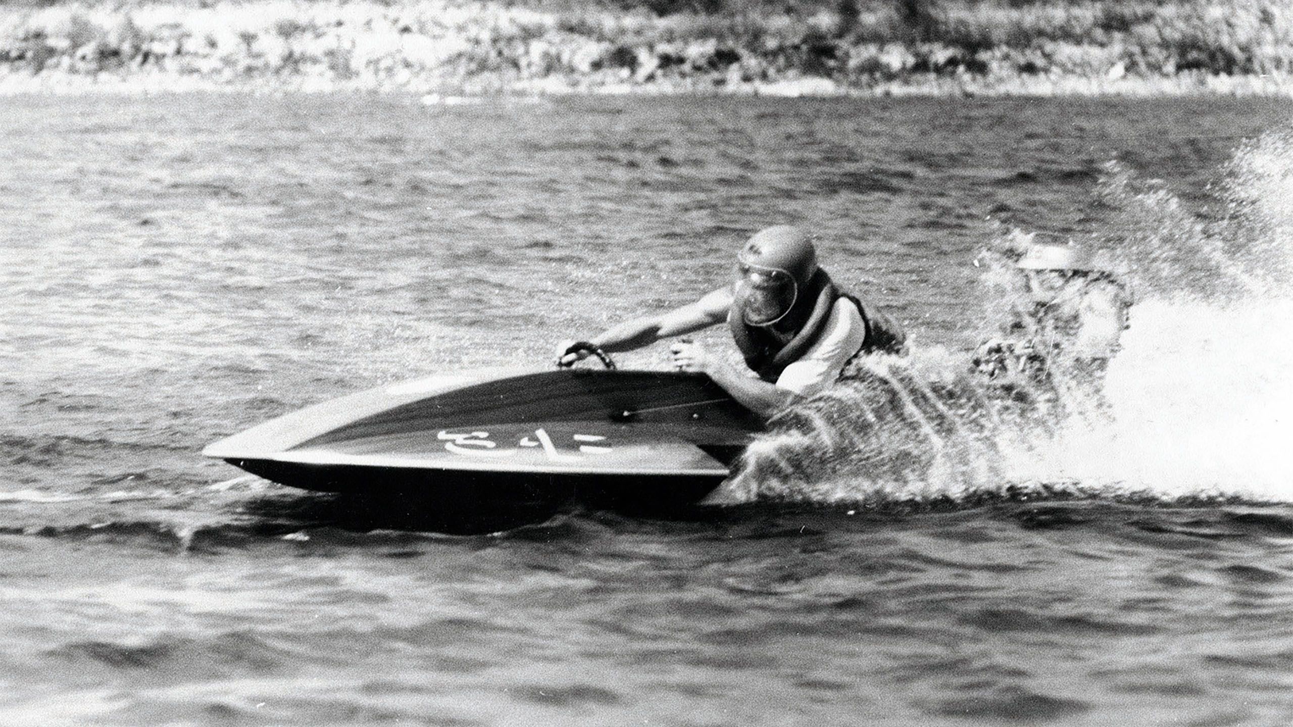 Black and white photo of a young Miniea racing on the water